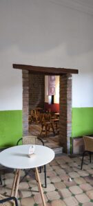 Arco de ladrillo que conecta con un segundo salón de mesas en Somos Legados Cali