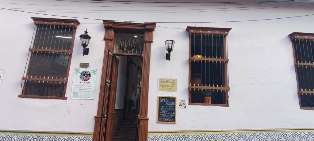 Entrada de Somos Legados Cali con aviso Café de Origen Nariño y pizarra del menú